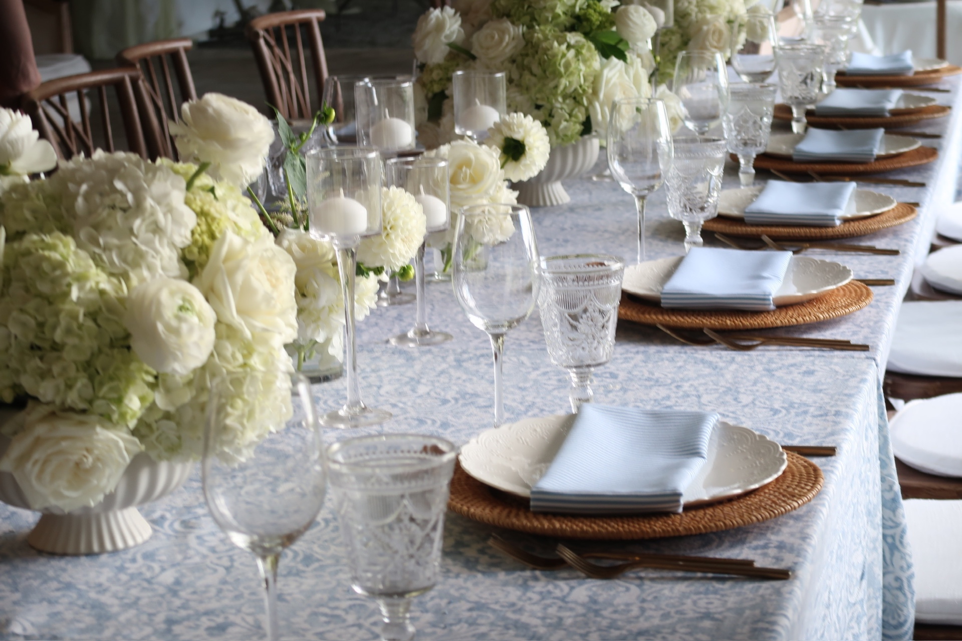 Long formal dining table with white floral arrangements and candles