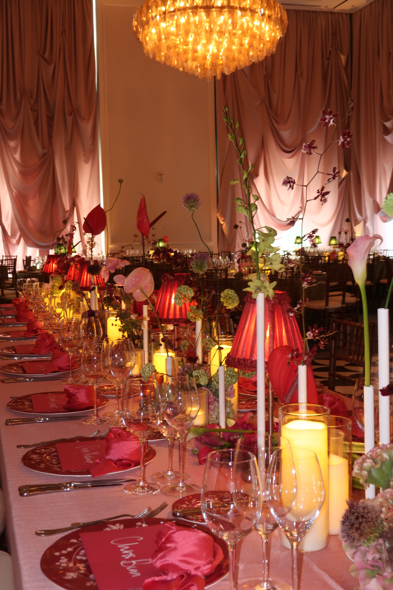 Candlelit wedding tablescape with red lamps and sculptural flowers