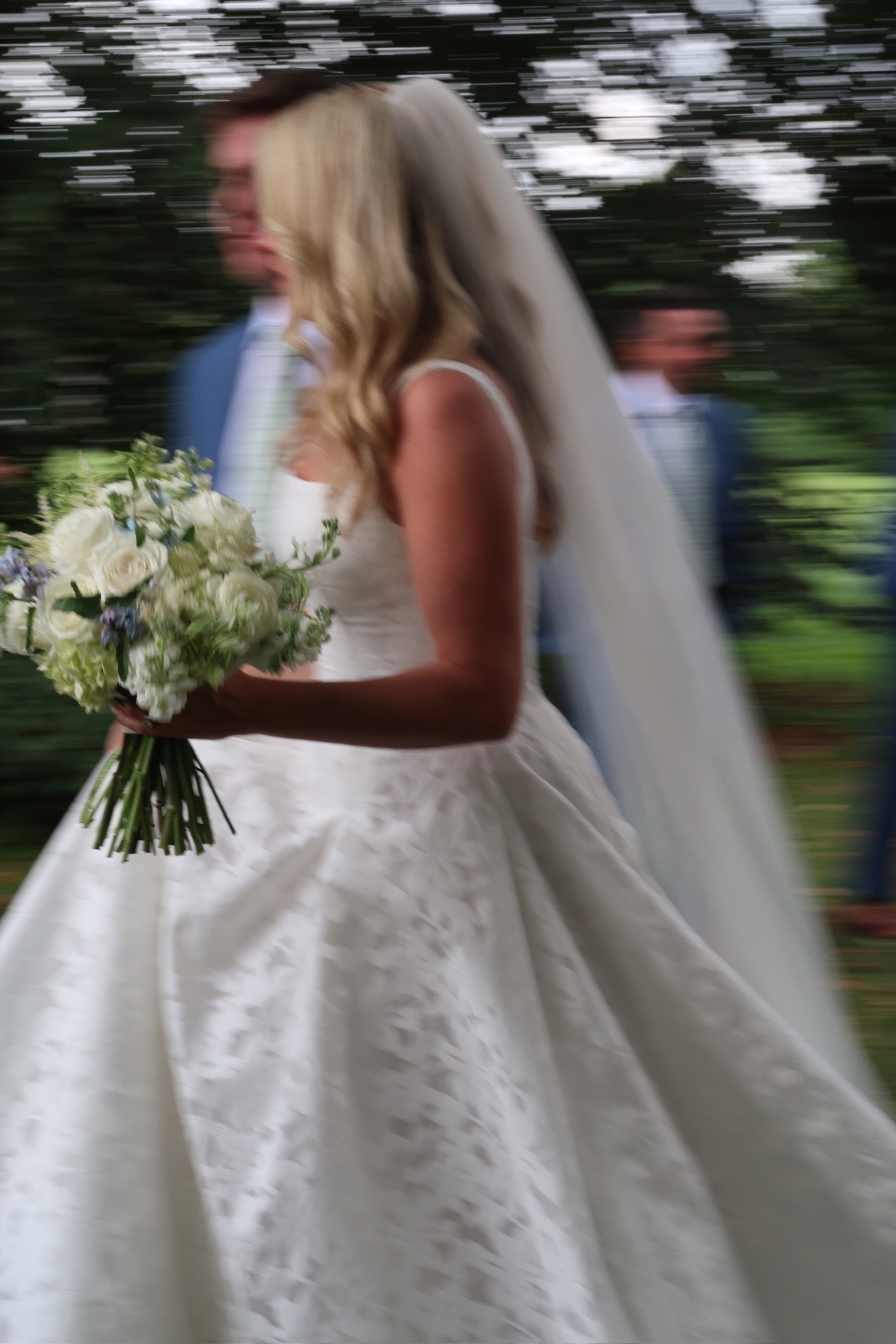 Bride in a white gown walking outdoors